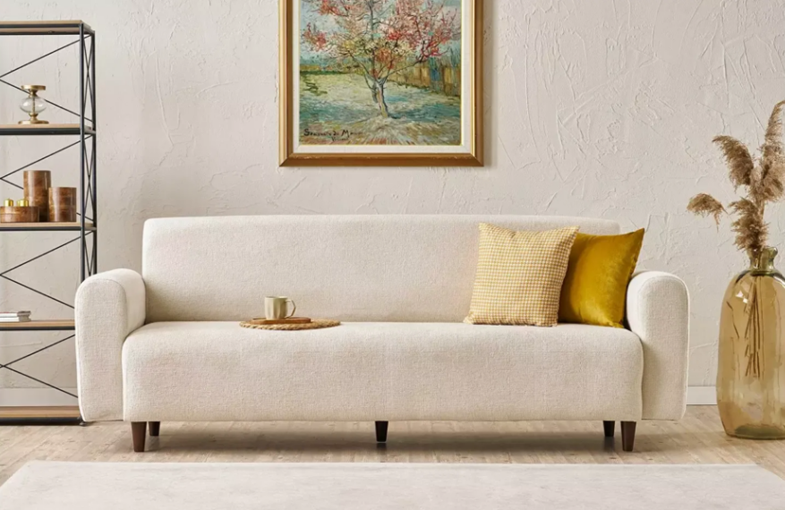 Krémszínű kanapé, tájkép a falon modern stúlusban